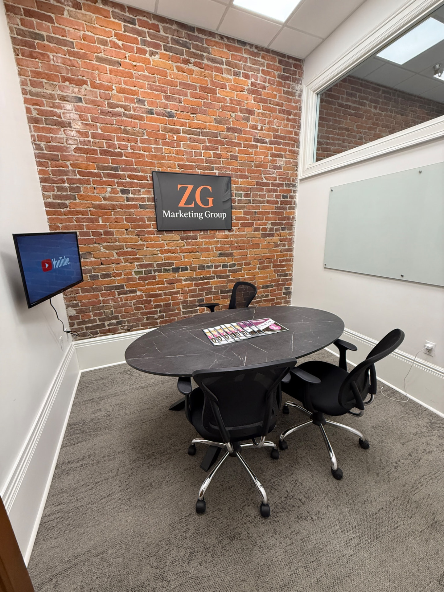 The ZG office meeting room with the ZG sign on the brick wall